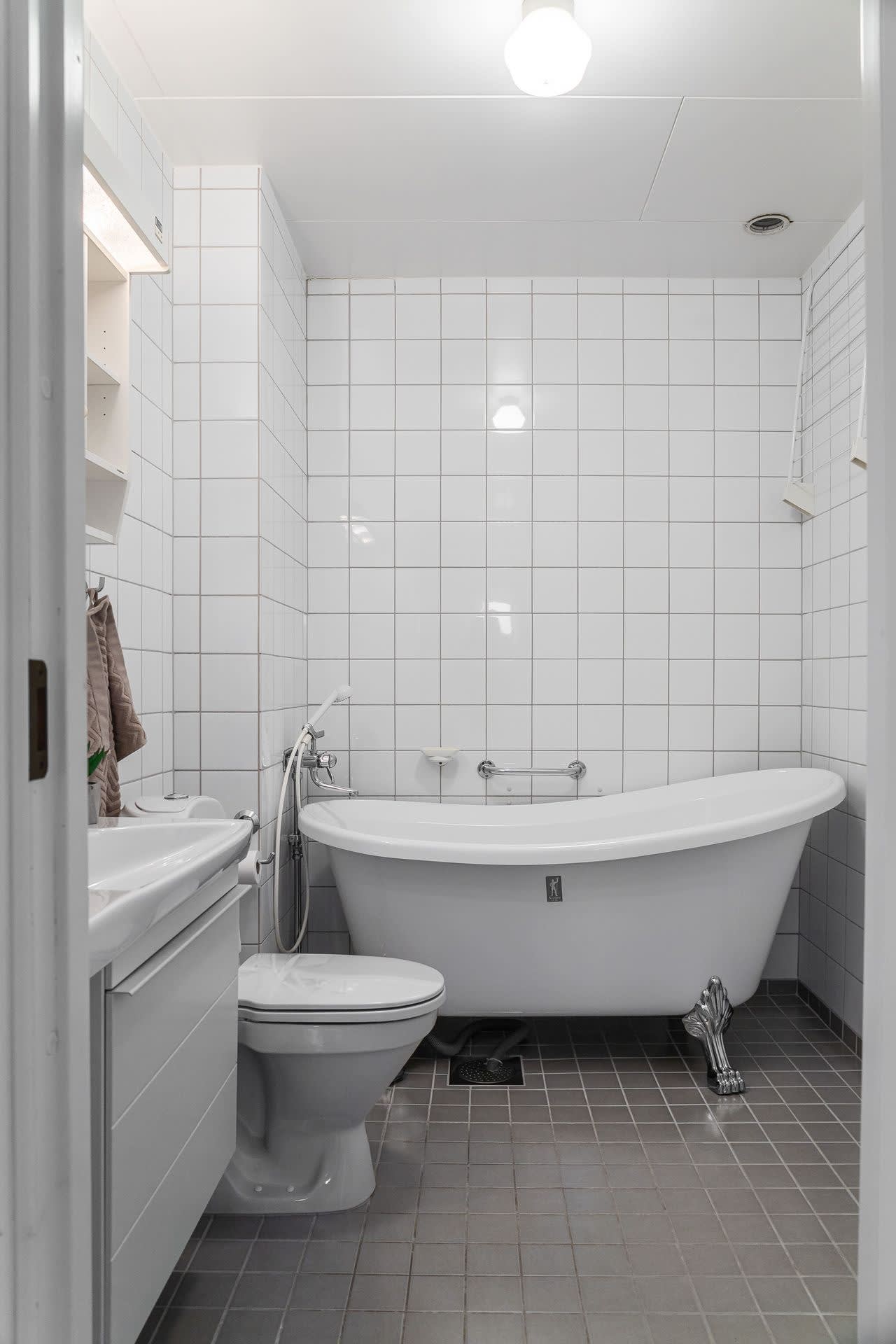 Badrummet på ovanvåningen är nyare och helkaklat med badkar på ?silvertassar?