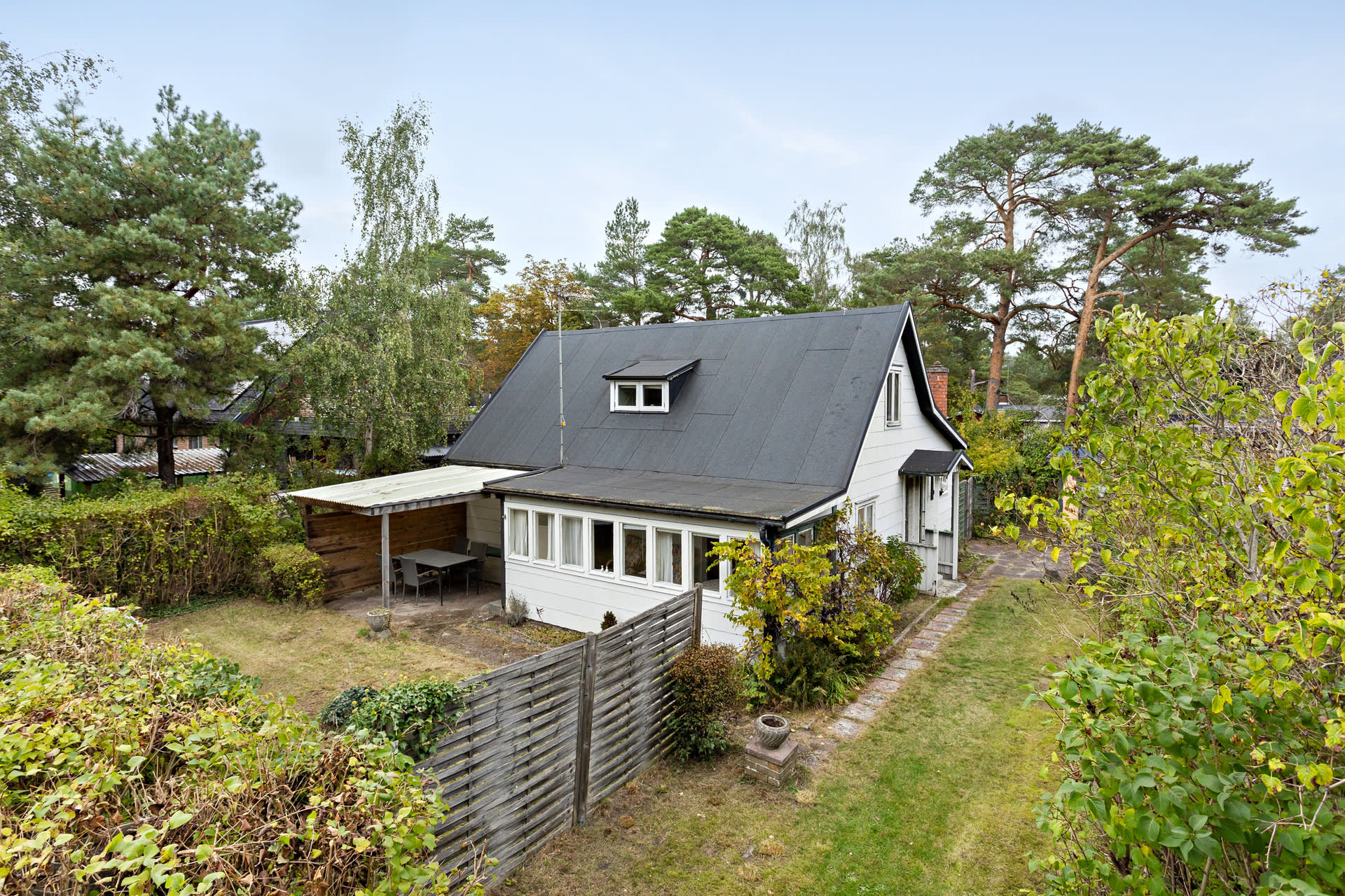 Framsida på huset till tre lägenheter med grönskande tomt