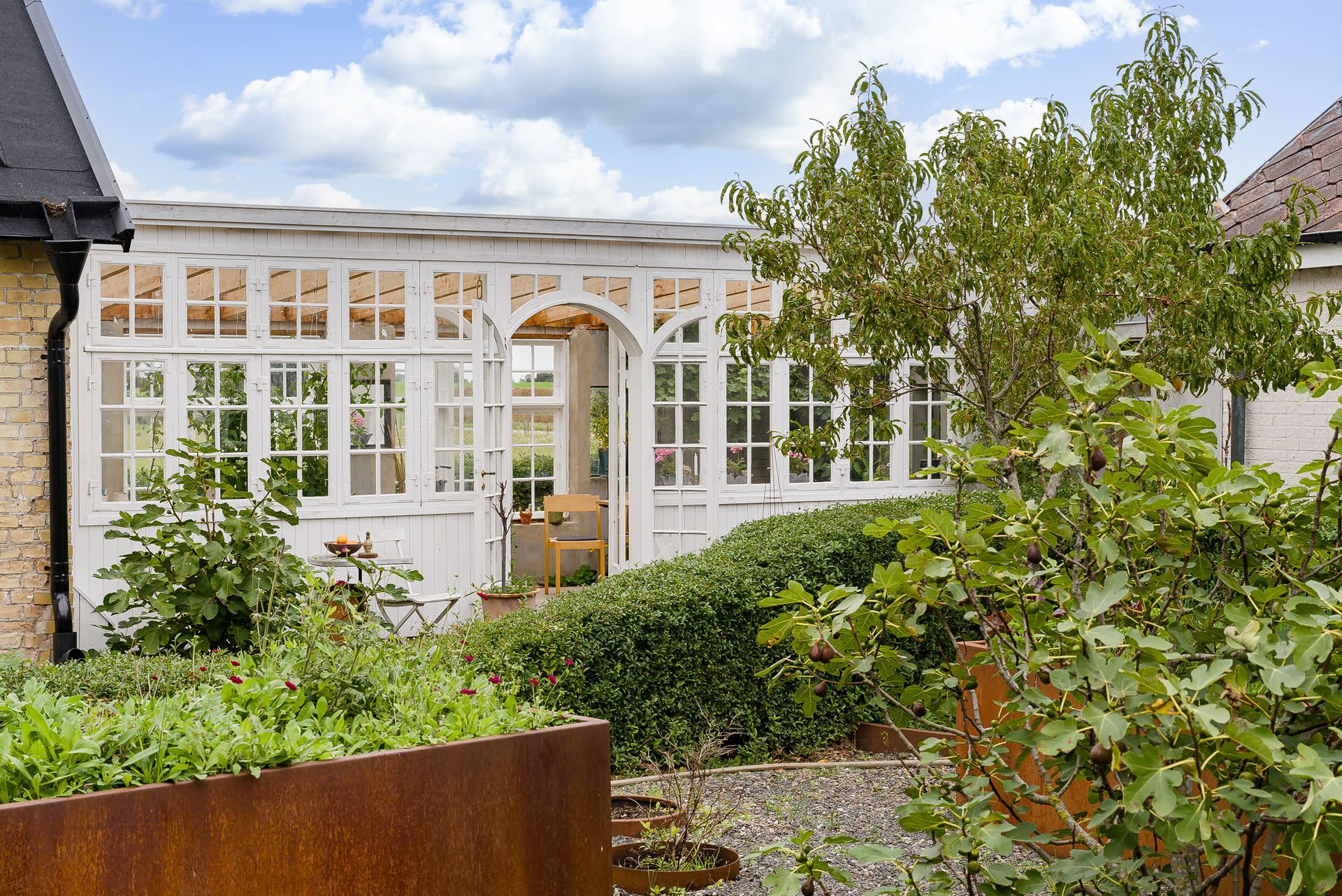 Växthus som länkar samman gården och blir ett romantiskt inslag i trädgården
