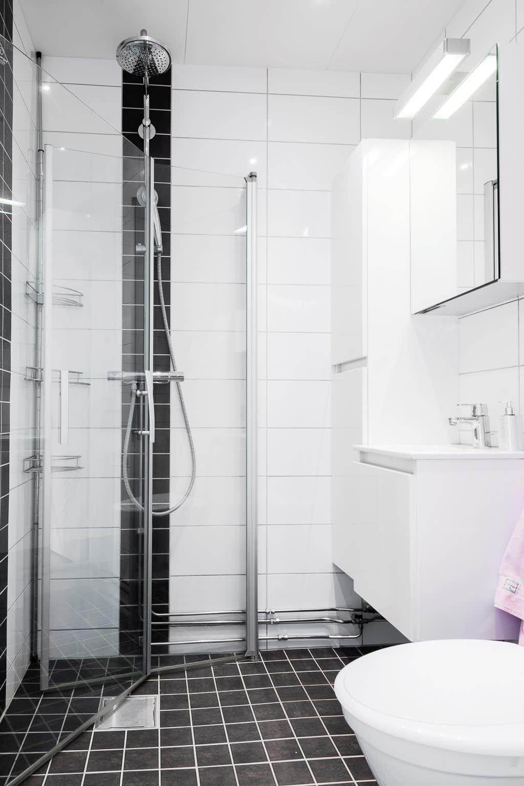 Välutrustat badrum med bekvämligeheter som takdusch, spotlightbelysning, golvvärme och handdukstork