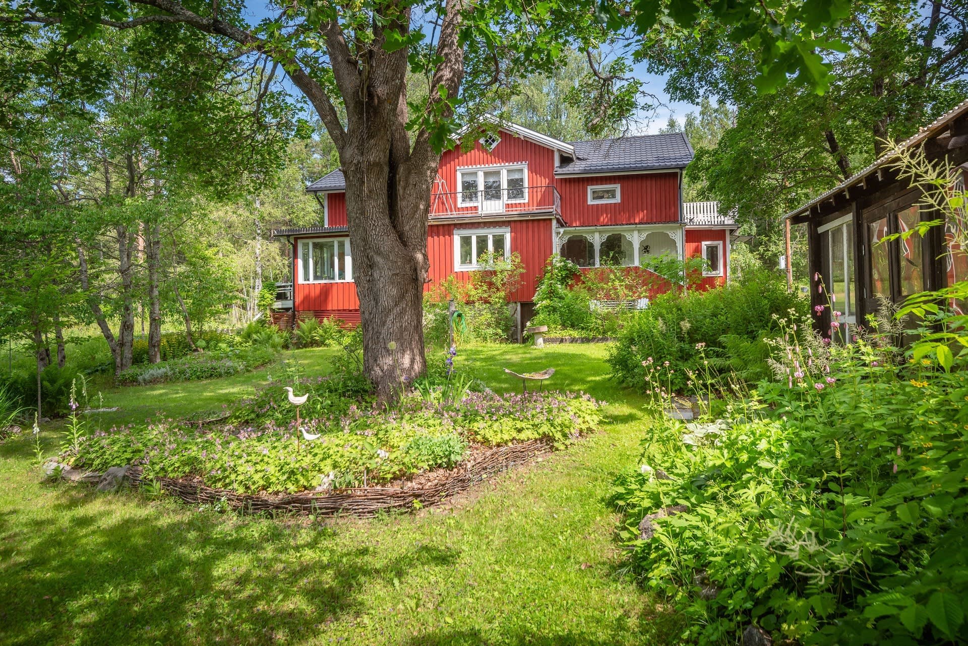 Bostadshuset från den grönskande trädgården.