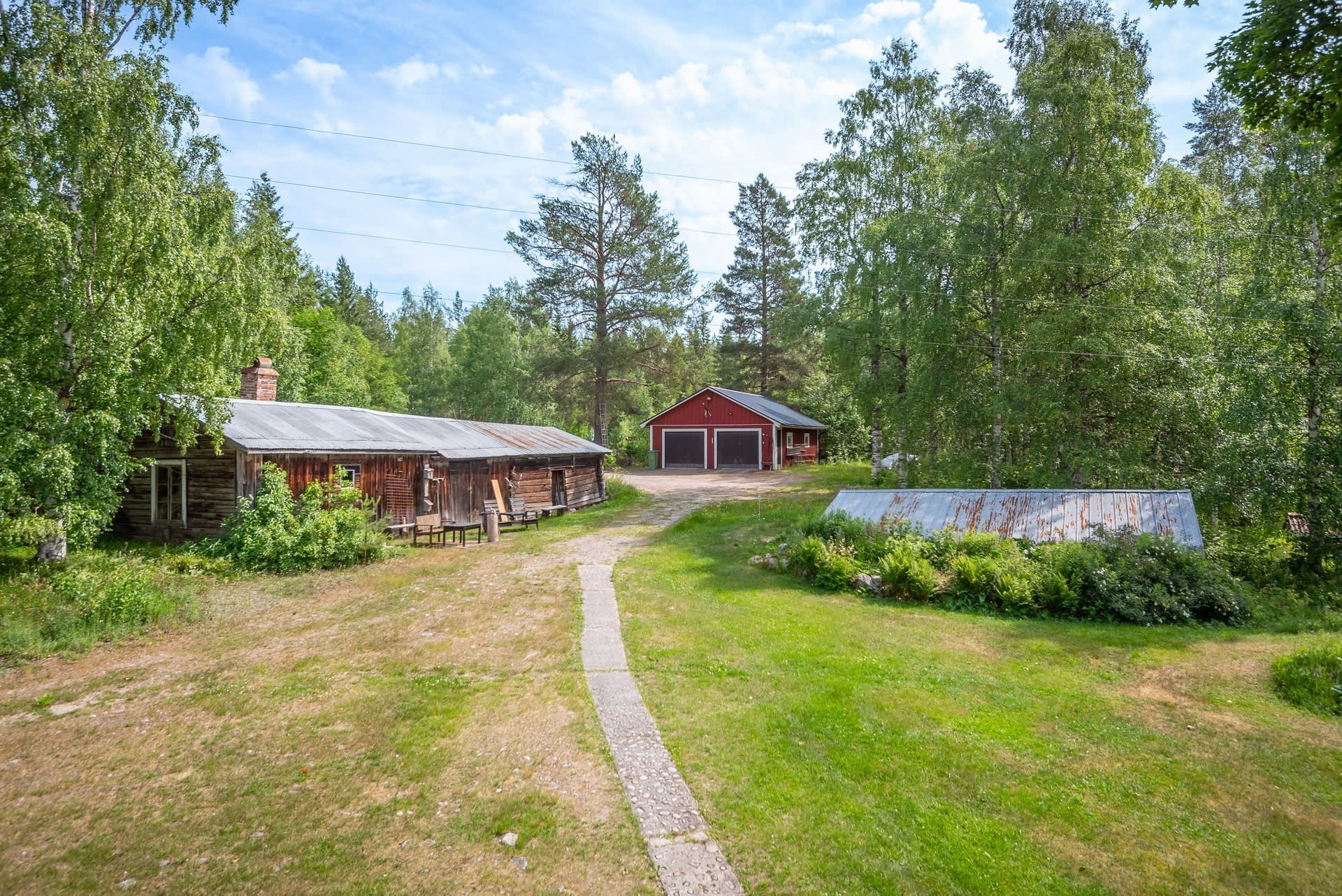 Äldre gårdslänga och rymligt garage med dubbla portar.